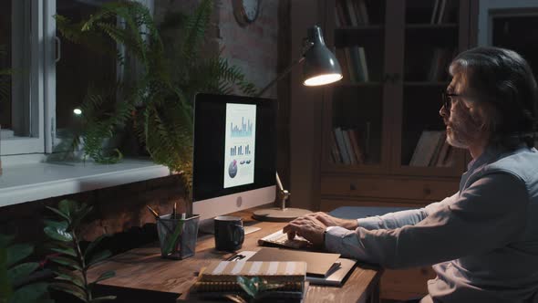 Office Worker Preparing Monthly Report At Night