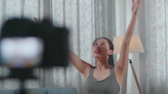 Trainer Female In Sports Clothes Speaking To Camera And Doing Yoga In High Lunge Pose