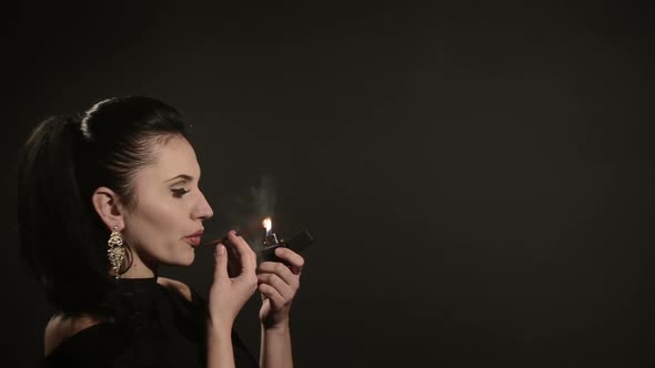 Beautiful Woman Lights a Cigarette on a Black Background