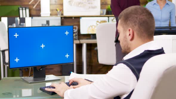 Bearded Architect Typing on Computer with Blue Screen