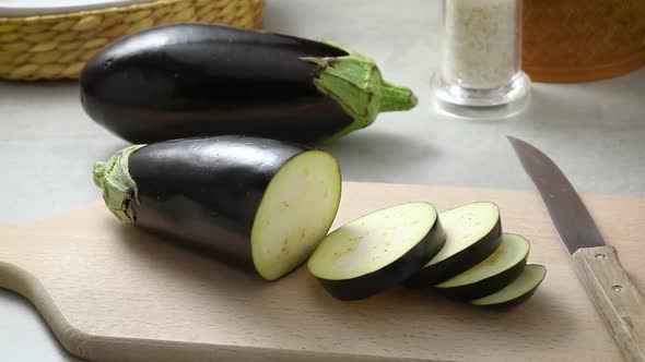 Fresh raw purple eggplant slices close up on a cutting board 