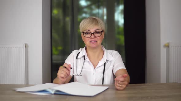 A Blonde Women Doctor with Short Haircut in Glasses is Giving Recommendations