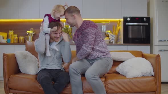 Carefree Gay Parents Kid Having Fun Couch