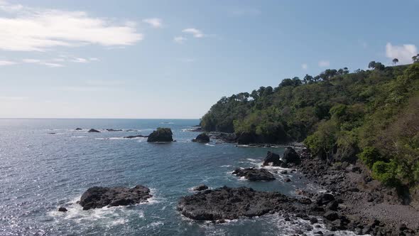 birds eye view of playitas shore where the pacific ocean meets the rocky coastline of costa rica