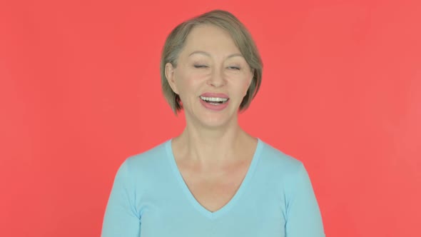 Old Woman Talking on Online Video Call on Red Background