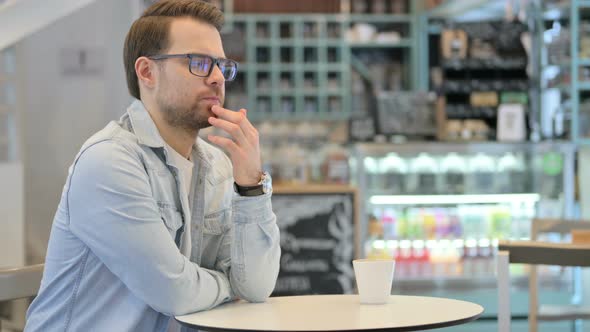 Pensive Man Thinking in Cafe