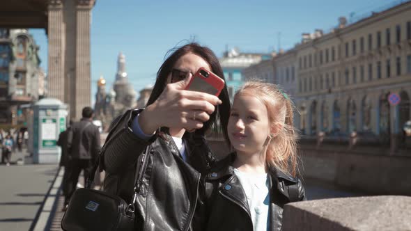 Mother and Daughter Teenager Taking Selfie Portrait on Smartphone in City. Family