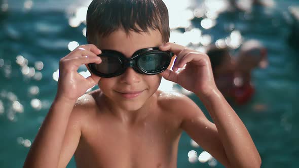 Boy child athlete puts on swimming goggles just before diving in competitions