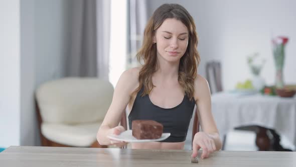 Portrait of Young Slim Woman Smelling Tasty Dessert Breaking Diet Eating Cake with Satisfied Facial