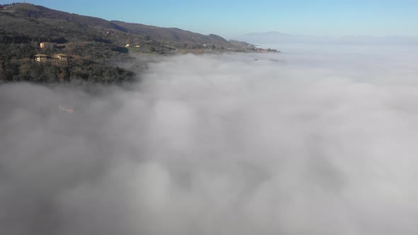 Aerial view of a houses and fog at mountain in Umbria, Italy