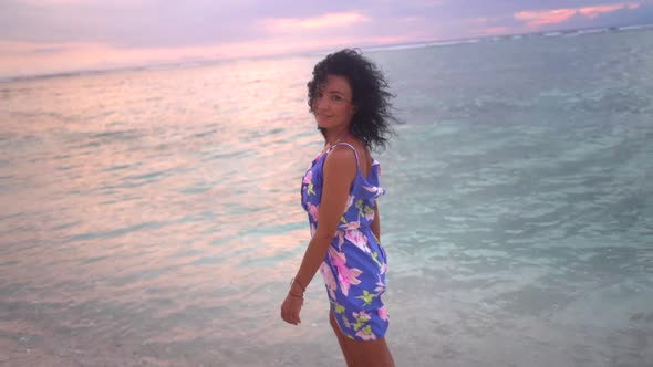 Happy Woman Tourist Trying the Fresh Sea Water with Barefoot on the Lovely Pink Sunset on the Sea