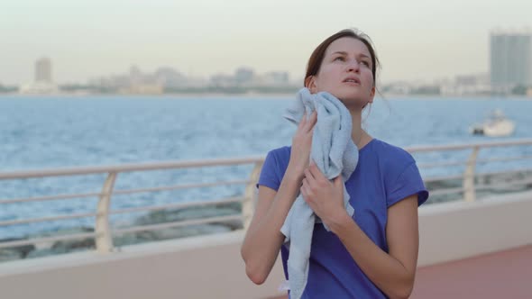 Girl Wipes Her Face with a Towel After Training.