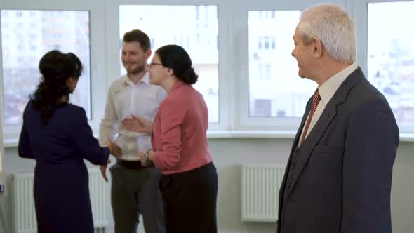 Senior Businessman Stands at the Office