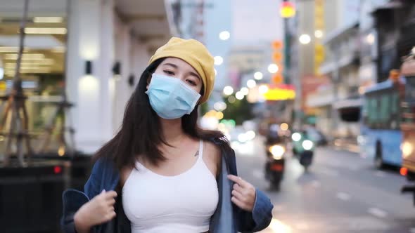 Asian woman standing outdoor wearing protective mask, covid-19 world pandemic