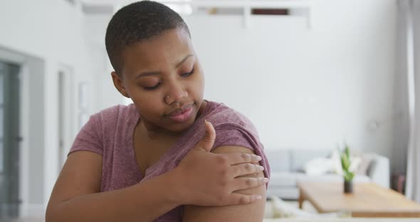 Portrait of smiling african american plus size woman with bandage on her arm after vaccination