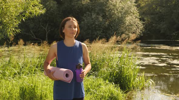 Woman walking in park after yoga class outdoors.