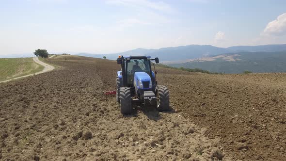 Farmer on tractor plowing a field in Umbria, Italy