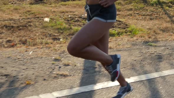 Girl Athlete Runs Along the Road. Legs. Slow Motion