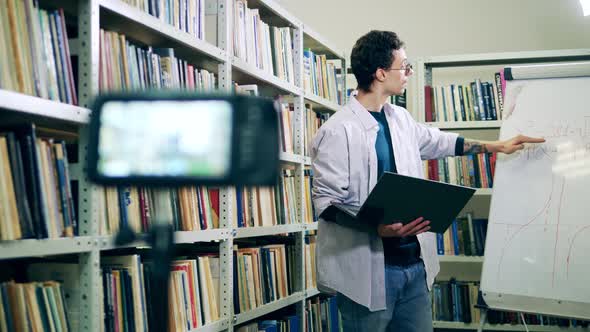 Teacher with Laptop Reading a Lecture To Remote Students