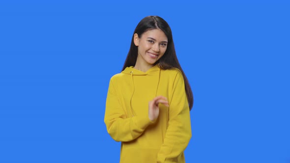 Portrait of Brunette Coquettishly Looking at Camera and Smiling