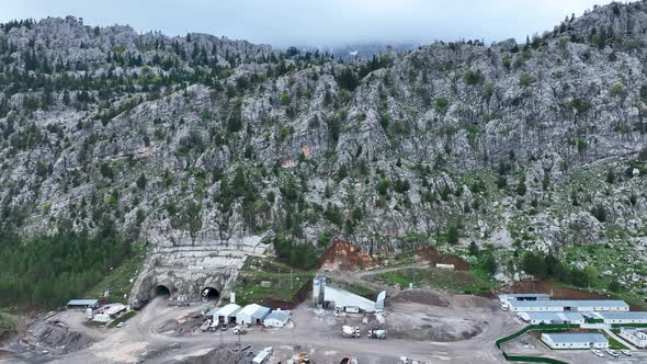 Heavy machinery drills tunnel through the mountain aerial view 4 K