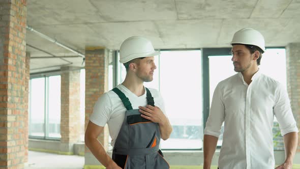 Two Architects are Walking Along the Building in Progress