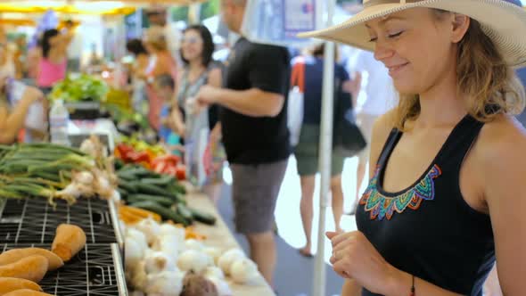 Young woman shopping at the local Farmers market.