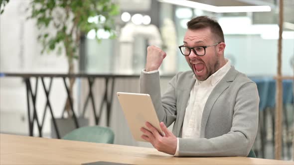 Excited Creative Man Celebrating Success on Tablet