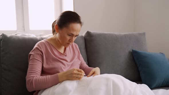 Woman Fold Towel and Sit on Sofa