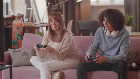Mother and Teenage Son Enjoying Console Game at Home
