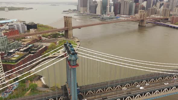 An aerial view over the East River on a cloudy day. The drone camera booms downward near the Manhatt