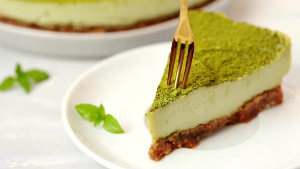 Slice of raw vegan matcha cake on white plate.