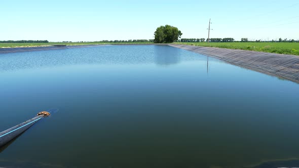 Irrigation Reservoir with Pipes. Man-made Special, Water Storage Pool, Tank for Agricultural Fields