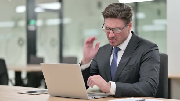 Tired Middle Aged Businessman with Laptop Having Neck Pain in Office