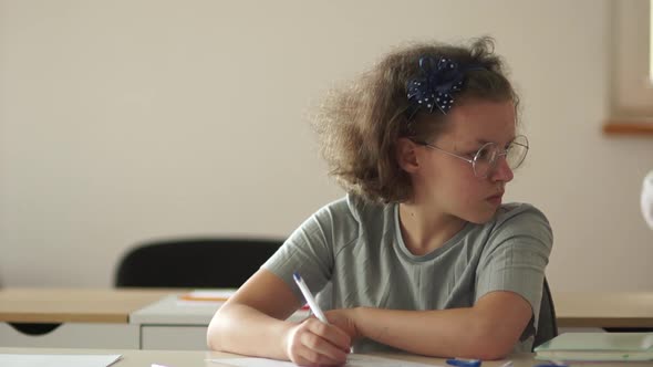 Back-to-school. Schoolchildren Are Sitting at Their Desks in Class. The Boy Is Late, the Girl Looks