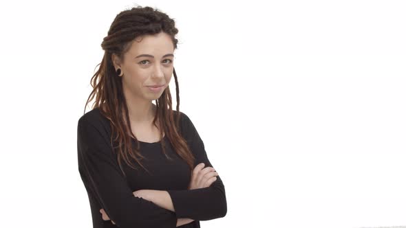 Cute Brunette Girl with Dreadlocks and Ear Tunnels Cross Arms Over Chest Looking Silly and Tender at