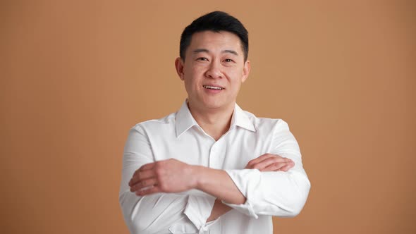 Smiling Asian man wearing white shirt looking at the camera