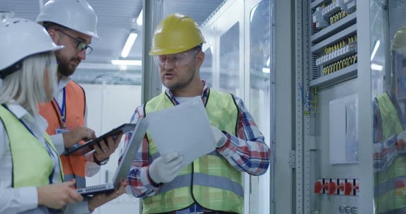 Three Electrical Workers Reviewing Documents