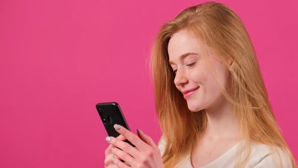 Happy Red Hared Woman with Freckles Making Selfie on Pink Background
