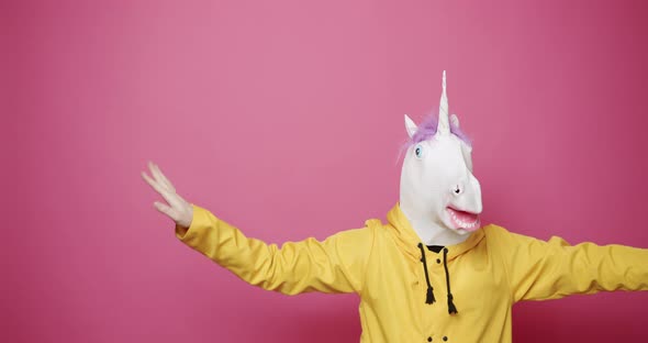 Happy Guy in Yellow Clothes Dance with Unicorn Mask