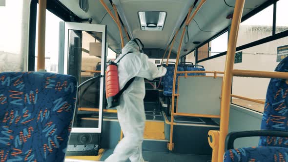 Disinfectors Use Sprayers To Sanitize a Bus From the Inside