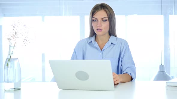 Young Woman Gesturing Shock at Work, Astonished