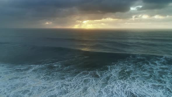 Aerial View on Big Waves and Dramatic Sunset Sky