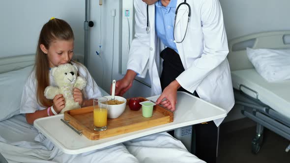 Doctor serving food to sick girl