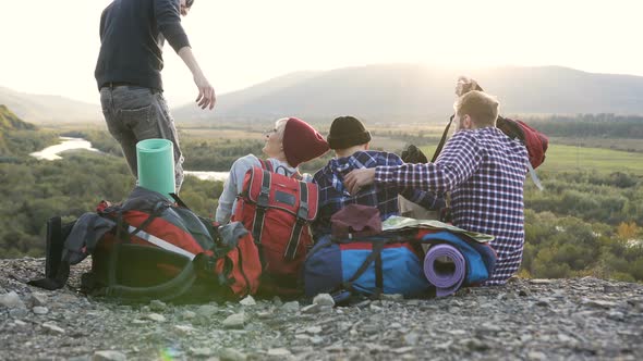 Happy Two Women Sitting on the Ground in the Mountain while Coming their Boyfriends