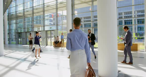 Caucasian businesswoman walking in the lobby at office 4k