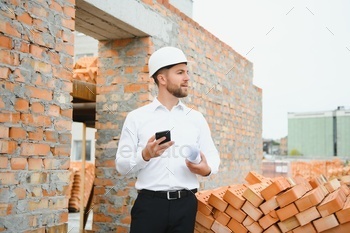 Construction concept of Engineer working at Construction Site with blue print.