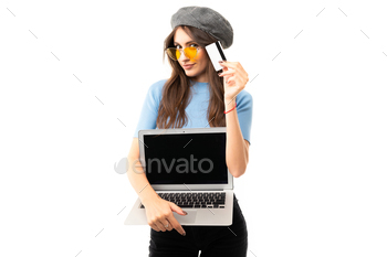 Cheerful woman with long hair holds a money card and laptop isolated on white background