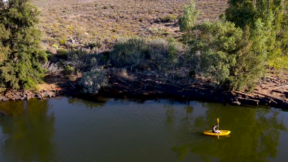Aerial view woman on yellow kayak, Western Cape, South Africa.
