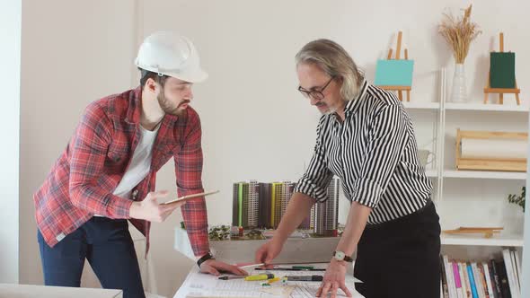 Young Engineer Man Mastering New Knowledge By Professional Architect